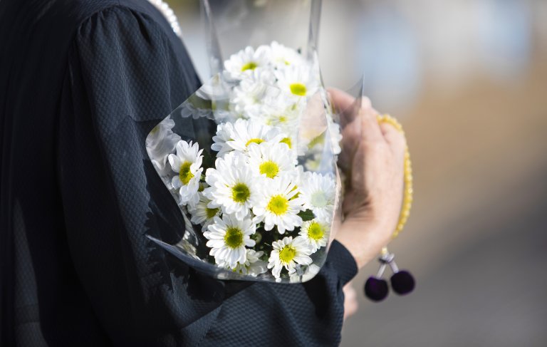 Osoba trzyma kwiaty w dłoniach